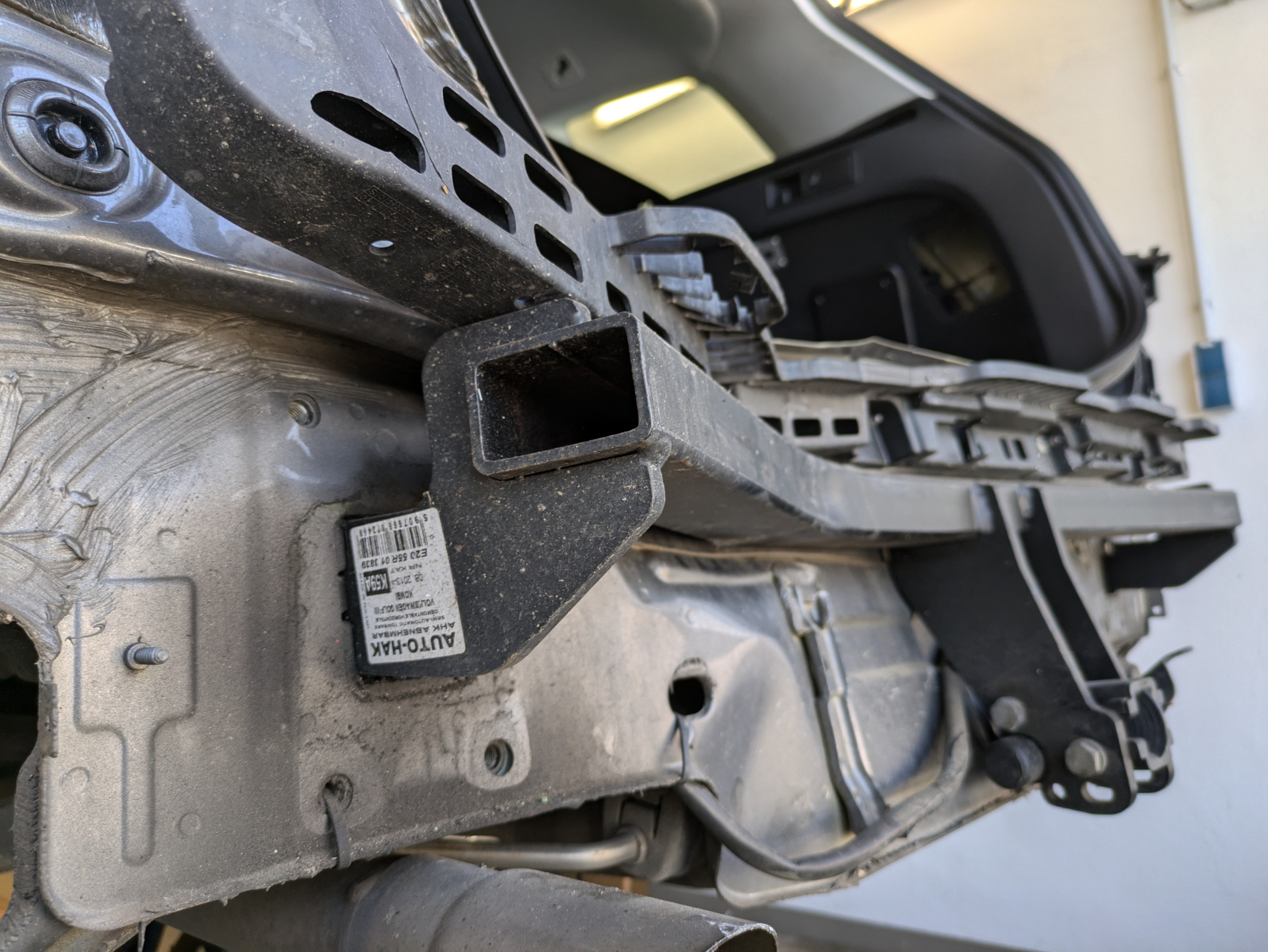 Im Zusammenhang einer Schadensfeststellung zählt das Freilegen zur Prüfung  von inneren Schäden zum Arbeitsumfang des Sachverständigen. Der Tragrahmen der Anhängerkupplung ist verzogen.